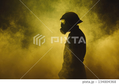 Cbrn soldier wearing gas mask stands in dense yellow smoke with protective helmet and uniform, creating dramatic and intense atmosphere for hazardous environment 134804368