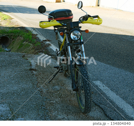 Yellow Motorcycle With Handguards Parked On Rough Road 134804840