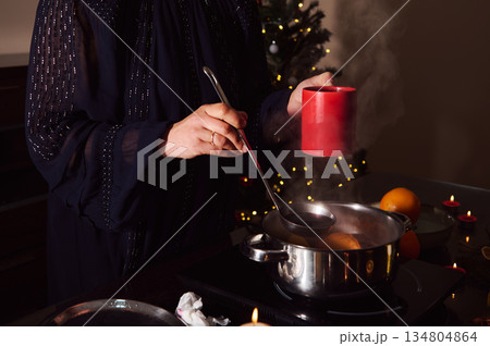 Elegant Woman In Evening Gown Preparing Mulled Wine By Candlelight Winter Holiday Scene 134804864