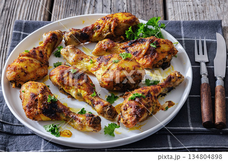 roasted chicken drumsticks on a white plate 134804898