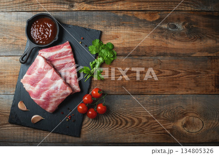 Raw pork ribs with spices, salt and rosemary on dark wooden background 134805326
