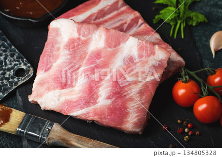 Raw meat. Raw pork ribs from the back with meat on a black background. background image 134805328