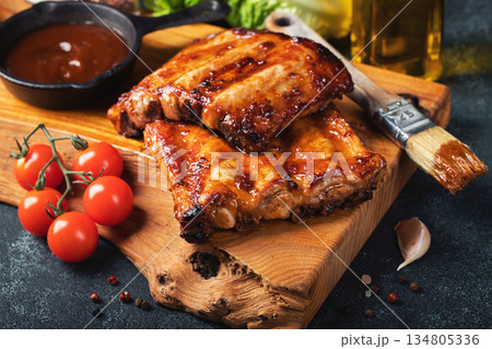 Spicy hot grilled spare ribs from a summer BBQ served with a hot chili pepper and fresh tomatoes Spicy hot grilled spare ribs from a summer BBQ served with a hot chili pepper and fresh tomatoes 134805336