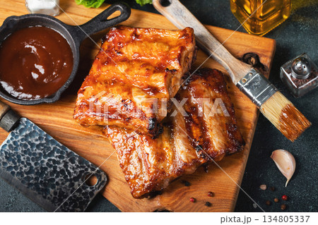 Spicy hot grilled spare ribs from a summer BBQ served with a hot chili pepper and fresh tomatoes Spicy hot grilled spare ribs from a summer BBQ served with a hot chili pepper and fresh tomatoes 134805337