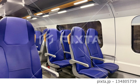 Modern Passenger Train Interior with Blue Seats, Empty Railway Carriage Modern Passenger Train Interior with Blue Seats, Empty Railway Carriage 134805739
