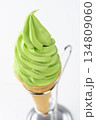 白背景の抹茶ソフトクリームコーンと金属スタンドのアップ 134809060