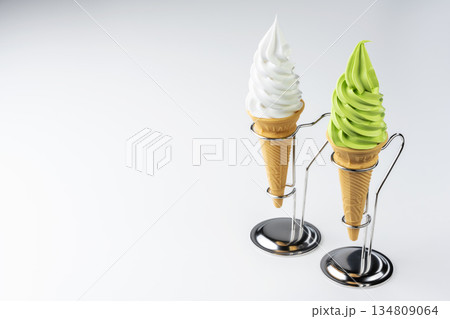 白背景に並ぶバニラと抹茶のソフトクリームコーン二つと余白 134809064