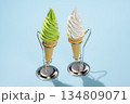 水色背景に立つ抹茶ソフトクリームコーンとバニラソフトクリームコーン 134809071