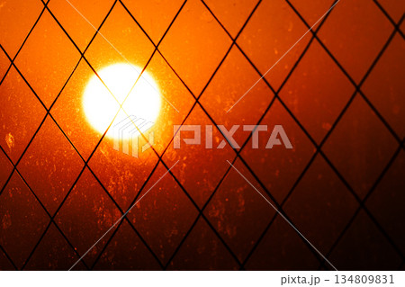 ホテルの窓から見たオレンジ色に輝く太陽 134809831