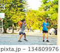 Two young girls playing basketball together on outdoor court 134809976