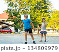Two young girls playing basketball together on outdoor court 134809979