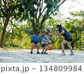 Happy Asian family playing basketball together on outdoor court at the park during golden hour. 134809984