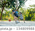 Happy Asian family playing basketball together on outdoor court at the park during golden hour. 134809988