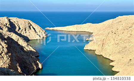 Bay Mouth Opening To Blue Sea, Gentle Tidal Flow Between Sandstone Cliffs With Azure Water Meeting Horizon, Calm Reflection And Navigation Potential For Coastal Survey And Maritime Lifestyle Visuals 134810338