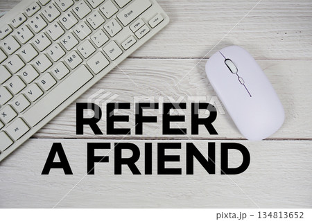 Refer A Friend text with keyboard and wireless mouse on wooden background 134813652