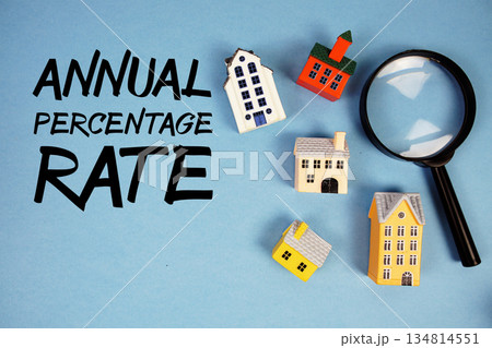 APR Annual Percentage Rate text with house models and magnifying glass on blue background APR Annual Percentage Rate text with house models and magnifying glass on blue background 134814551