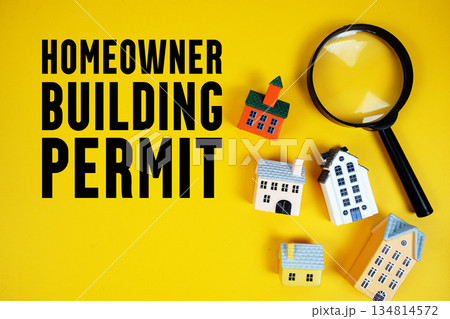 Homeowner Building Permit text with house models and magnifying glass on yellow background Homeowner Building Permit text with house models and magnifying glass on yellow background 134814572