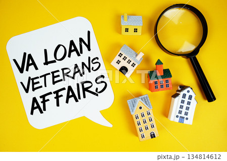 VA Veterans Affairs text with house models and magnifying glass on yellow background 134814612