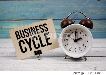 Business Cycle text written on paper card with alarm clock on wooden background Business Cycle text written on paper card with alarm clock on wooden background 134814858