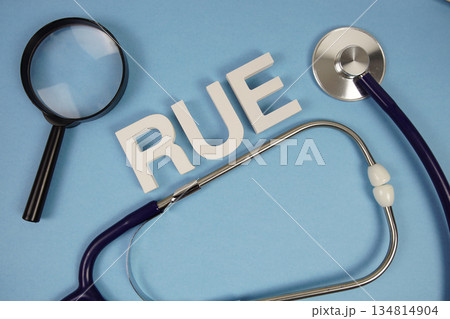 RUE abbreviation of Right Upper Extremity alphabet letters with magnifying glass and stethoscope on blue background RUE abbreviation of Right Upper Extremity alphabet letters with magnifying glass and stethoscope on blue background 134814904