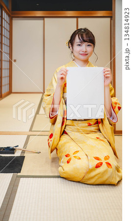 書き初めをする着物を着た若い女性 134814923