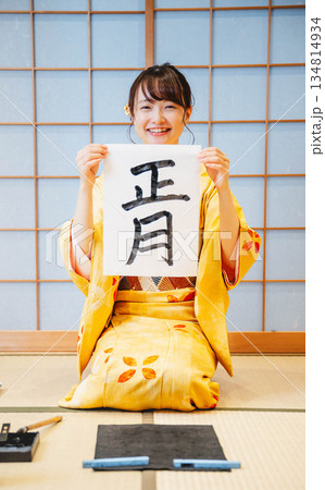 書き初めをする着物を着た若い女性 134814934