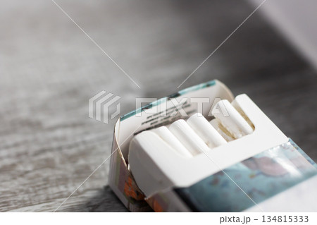 Reflective scene showing unlit cigarette pack illuminated softly in evening ambiance 134815333