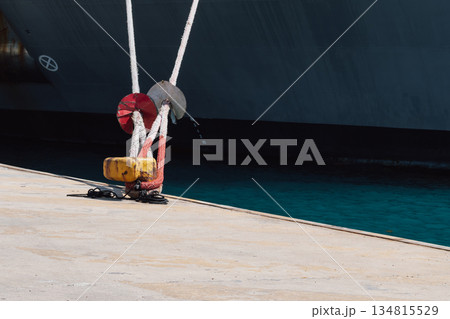 Mooring of a vessel in the port using mooring lines to a bollard on the quay Mooring of a vessel in the port using mooring lines to a bollard on the quay 134815529