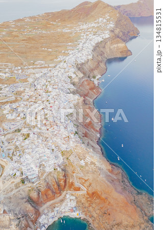 Bird's-eye view capturing the dramatic volcanic caldera and the famous cliffside villages Santorini Bird's-eye view capturing the dramatic volcanic caldera and the famous cliffside villages Santorini 134815531