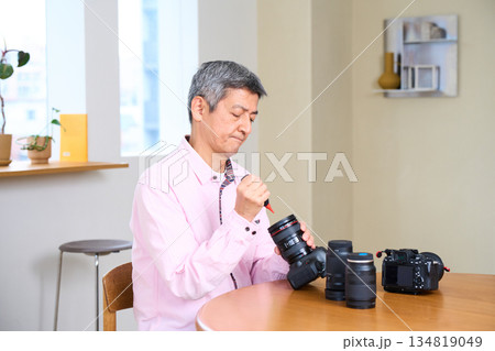 写真撮影を趣味にする男性シニア　カメラ　手入れ　メンテナンス 134819049