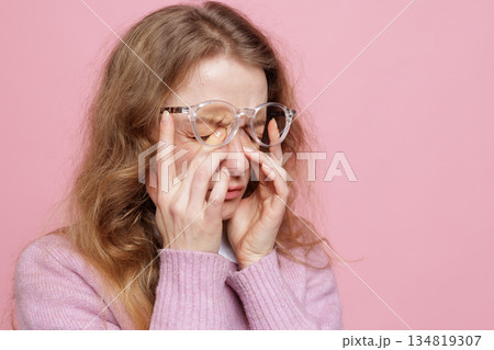 Side view portrait of woman pressing eyes in glasses showing dry eye irritation and headache from screen fatigue Side view portrait of woman pressing eyes in glasses showing dry eye irritation and headache from screen fatigue 134819307