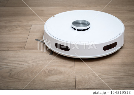 Autonomous Robot Vacuum Cleaner Operating On Clean Wooden Floor Surface 134819518