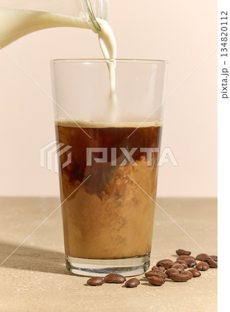 milk pouring in glass of coffee milk pouring in glass of coffee 134820112
