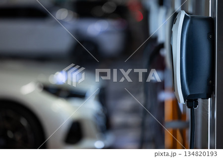 EV charging and electric car, Electric car charging station for charge EV battery, Plug for vehicle with electric engine, EV charger clean energy, Charging point at car parking lot 134820193