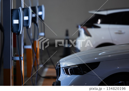 EV charging and electric car, Electric car charging station for charge EV battery, Plug for vehicle with electric engine, EV charger clean energy, Charging point at car parking lot 134820196