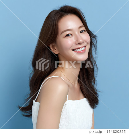 青背景に映える笑顔の若い女性・バストアップ・白キャミソール 134820825