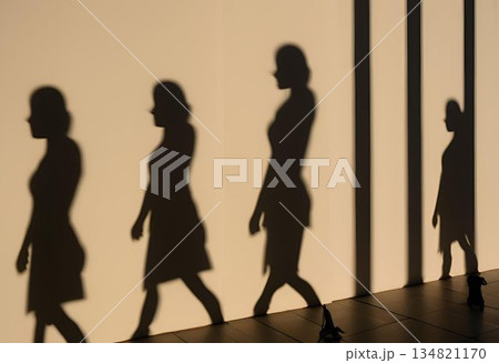 Elegant silhouettes walking against a warm minimalist wall. AI Generated 134821170