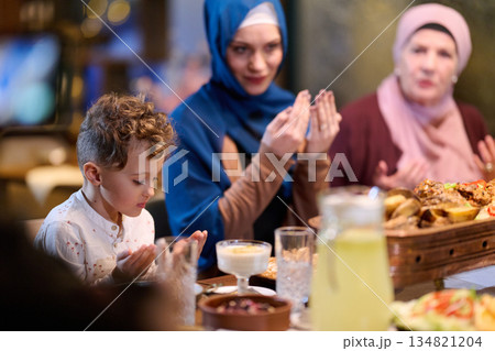 Muslim family enjoying iftar at restaurant with Ramadan decorations during the holy month Muslim family enjoying iftar at restaurant with Ramadan decorations during the holy month 134821204