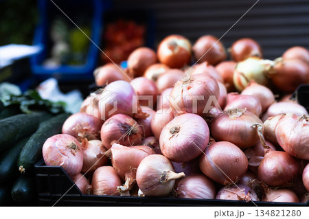 Box is filled with onions, grocery store display case. 134821280