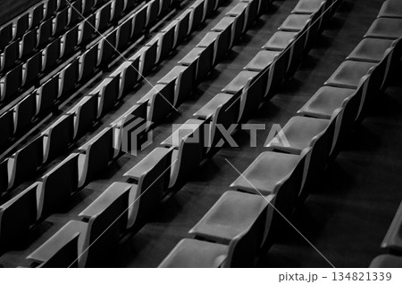 Empty seats in stadium stands. Black and white photo without fans. Empty seats for sports spectators. Empty rows without spectator support. Importance of support from stands, no one came to game Empty seats in stadium stands. Black and white photo without fans. Empty seats for sports spectators. Empty rows without spectator support. Importance of support from stands, no one came to game 134821339