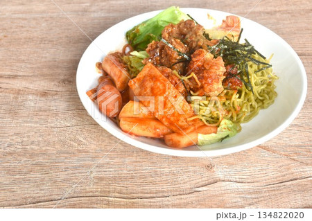 Korean vegetable noodles topping tokpokki slice pork sausage and cabbage with tofu dressing spicy sauce couple fried chicken topping dry seaweed on plate Korean vegetable noodles topping tokpokki slice pork sausage and cabbage with tofu dressing spicy sauce couple fried chicken topping dry seaweed on plate 134822020