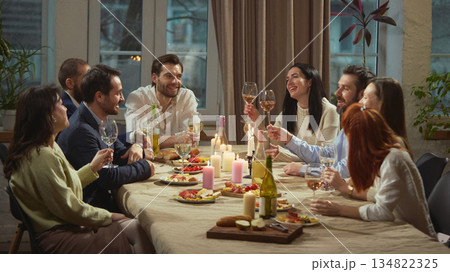 Group of people laughing and holding wine glasses at dinner. Group of people laughing and holding wine glasses at dinner. 134822325