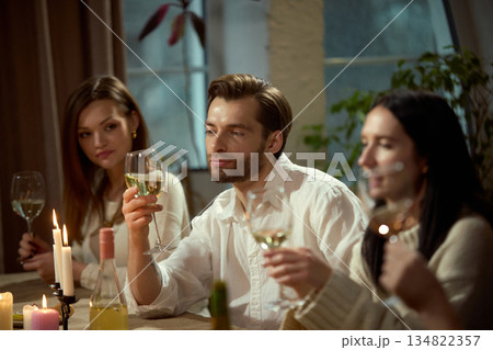 Man holding wine glass during dinner conversation. Man holding wine glass during dinner conversation. 134822357