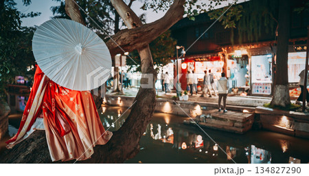 Traditional Attire Under Tree With Parasol Beside Waterway at Dusk. Zhujiajiao, Shanghai, China 134827290
