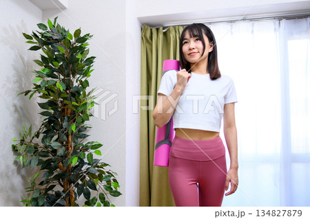 ヨガウェアでトレーニングジム、ヨガスタジオに向かう日本人女性 ヨガマット レギンス トリミングアップ ヨガウェアでトレーニングジム、ヨガスタジオに向かう日本人女性 ヨガマット レギンス トリミングアップ 134827879