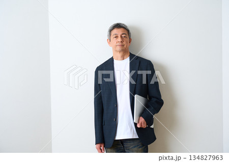 ジャケットとデニムで立つシニア男性 ジャケットとデニムで立つシニア男性 134827963