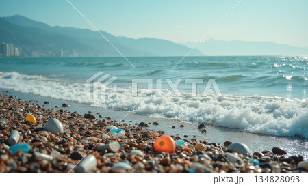 Plastic waste and debris on pebble beach near ocean waves. Environmental pollution and marine conservation concept 134828093
