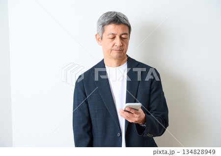 スマートフォンを操作するシニア男性 134828949