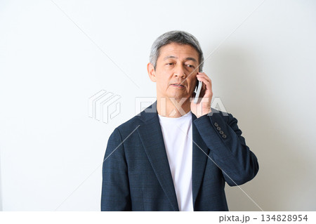 白背景で電話をするシニア男性 白背景で電話をするシニア男性 134828954