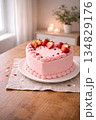 Valentine's pink heart-shaped cake decorated with strawberries on wooden table 134829176